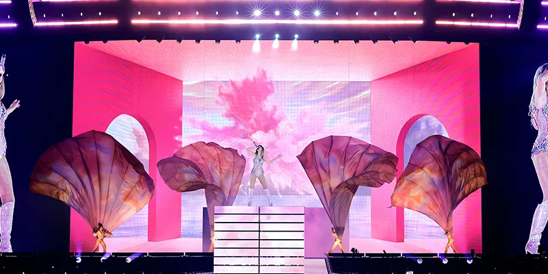 A live event stage with a wide illuminated LED backdrop